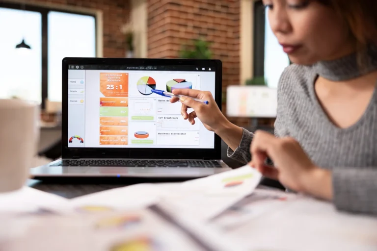 office worker pointing laptop screen 200kb